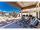 Cozy covered patio with outdoor seating and a view of the landscaped backyard at 8054 E 152Nd Dr, Thornton, CO 80602
