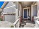 Welcoming front entrance with gray door, light-colored siding, and an attached two-car garage at 8054 E 152Nd Dr, Thornton, CO 80602