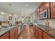 Open concept kitchen with wooden cabinets, stainless steel appliances, and hardwood floors at 8054 E 152Nd Dr, Thornton, CO 80602