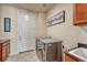 Well-lit laundry room featuring a front loading washer and dryer and access to a door and countertops at 8054 E 152Nd Dr, Thornton, CO 80602