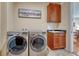 Well-lit laundry room featuring a front loading washer and dryer and a sink with dark countertops at 8054 E 152Nd Dr, Thornton, CO 80602