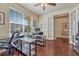 Well-lit office space with hardwood floors, offering two work areas and glass French doors at 8054 E 152Nd Dr, Thornton, CO 80602