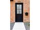 Modern black front door on a red brick building with a small walkway at 3408 W 17Th Ave, Denver, CO 80204