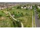 Aerial view of a community park with playground, walking path, and lush green space surrounded by houses at 5745 N Genoa Way # 306, Aurora, CO 80019