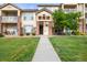 Apartment building exterior featuring well-maintained landscaping, brick accents, and a welcoming entrance at 5745 N Genoa Way # 306, Aurora, CO 80019