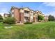 Well-manicured lawn complements the brick facade of this multi-story condo building with manicured lawn at 5745 N Genoa Way # 306, Aurora, CO 80019