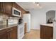 Cozy kitchen featuring white appliances, a microwave, and wood cabinets at 5745 N Genoa Way # 306, Aurora, CO 80019