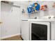 Well-lit laundry room featuring a modern washer and dryer, complemented by ample overhead shelving for storage at 5745 N Genoa Way # 306, Aurora, CO 80019