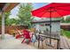 Inviting back patio with red Adirondack chairs, umbrella-covered table, and lovely garden area at 4220 Quitman St, Denver, CO 80212