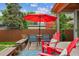 Backyard patio area featuring outdoor seating, a red umbrella, and a bench, perfect for relaxing at 4220 Quitman St, Denver, CO 80212