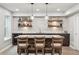 Modern bar area featuring floating shelves, a sink, and a wooden bar with seating for three at 4220 Quitman St, Denver, CO 80212