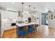 Modern kitchen featuring white cabinets, a blue island with bar stools, and stainless steel appliances at 4220 Quitman St, Denver, CO 80212