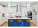 Modern kitchen with white cabinets, stainless steel appliances, and a blue kitchen island at 4220 Quitman St, Denver, CO 80212