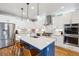 Modern kitchen featuring white cabinets, a blue island with bar stools, and stainless steel appliances at 4220 Quitman St, Denver, CO 80212