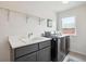 Well-lit laundry room with modern washer and dryer, sink, quartz countertop, and storage shelf at 4220 Quitman St, Denver, CO 80212