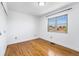 This is a bright bedroom with hardwood floors and a large window at 12829 E Nevada Ave, Aurora, CO 80012