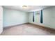 Cozy bedroom with light blue walls, carpet, and a window with curtains, creating a peaceful retreat at 12829 E Nevada Ave, Aurora, CO 80012