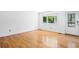 Bright bedroom features hardwood floors, white walls, and a window with a lush green view at 12829 E Nevada Ave, Aurora, CO 80012