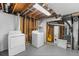 Unfinished basement laundry area featuring washer, dryer, water heater and exposed mechanicals at 12829 E Nevada Ave, Aurora, CO 80012