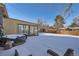 Snowy backyard with a hot tub and patio; great for outdoor relaxation at 7625 W 23Rd Pl, Lakewood, CO 80214