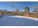 Spacious backyard with a wooden fence, covered in snow at 7625 W 23Rd Pl, Lakewood, CO 80214