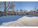 Large backyard with a snow-covered lawn and a sunroom addition at 7625 W 23Rd Pl, Lakewood, CO 80214