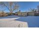 Winter view of backyard with snow-covered lawn and sunroom at 7625 W 23Rd Pl, Lakewood, CO 80214