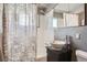 Updated bathroom with a stylish vessel sink and gray patterned shower curtain at 7625 W 23Rd Pl, Lakewood, CO 80214