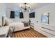 Bright bedroom with a queen-size bed, dresser, and wood-look floors at 7625 W 23Rd Pl, Lakewood, CO 80214