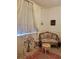Charming bedroom corner featuring a floral loveseat and a decorative window with sheer curtains at 8500 E Jefferson Ave, Denver, CO 80237