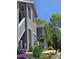Charming townhome with new siding, complemented by colorful flowers and lush trees, creating a welcoming curb appeal at 8500 E Jefferson Ave, Denver, CO 80237