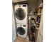 Convenient laundry room featuring a stacked washer and dryer and storage shelves at 8500 E Jefferson Ave, Denver, CO 80237
