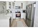 Bright kitchen featuring stainless steel appliances, white cabinetry, and a center island with a sink at 8500 E Jefferson Ave # G, Denver, CO 80237