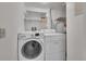 Practical laundry room equipped with a washer, dryer, and shelving for storage at 6410 S Dayton St # I1, Englewood, CO 80111