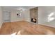 Bright living room with wood floors, a stone fireplace, and a pass-through to the kitchen at 6410 S Dayton St # I1, Englewood, CO 80111