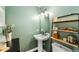 Modern bathroom with green walls, pedestal sink, and floating shelves at 4270 Irving St, Denver, CO 80211