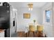 Cozy dining area with hardwood floors, modern lighting, and stainless steel refrigerator at 4544 W 65Th Ave, Arvada, CO 80003