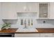 Bright kitchen with white cabinets, subway tile backsplash, and butcher block counters at 4544 W 65Th Ave, Arvada, CO 80003