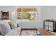 Bright living room featuring hardwood floors, a cozy couch, and a view of the front yard at 4544 W 65Th Ave, Arvada, CO 80003
