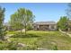 Expansive backyard featuring lush lawn, mature trees, and covered patio is perfect for outdoor living and entertaining at 16550 Antero Cir, Broomfield, CO 80023