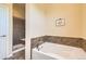 Bathroom boasting soaking tub and tiled walk-in shower with glass door at 16550 Antero Cir, Broomfield, CO 80023