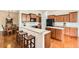 Bright, open kitchen with wood cabinets, quartz countertops, an island with breakfast bar, and modern appliances at 16550 Antero Cir, Broomfield, CO 80023