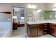 Bathroom features a vanity with double sinks, a large mirror, and a view into the main bedroom at 13713 Raritan Ln, Broomfield, CO 80023