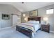 Spacious main bedroom featuring a large bed, neutral walls, and a sliding barn door to the bathroom at 13713 Raritan Ln, Broomfield, CO 80023