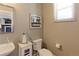 This powder room features a sink, toilet, window and neutral paint at 13713 Raritan Ln, Broomfield, CO 80023