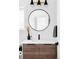 Modern bathroom vanity with a round mirror, sleek faucet, and wooden cabinetry at 3927 N Cook St, Denver, CO 80205