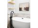 Stylish white bathtub features a black faucet and marble tile surround at 3927 N Cook St, Denver, CO 80205