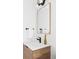 Modern bathroom with wood vanity, white countertop, black faucet, gold mirror, and towel rack at 3927 N Cook St, Denver, CO 80205