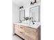 Double vanity in a bright bathroom with wood cabinets, black fixtures, and modern lighting at 3927 N Cook St, Denver, CO 80205