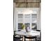 Close-up of round dining table with modern light fixture and bright light from large windows at 3927 N Cook St, Denver, CO 80205